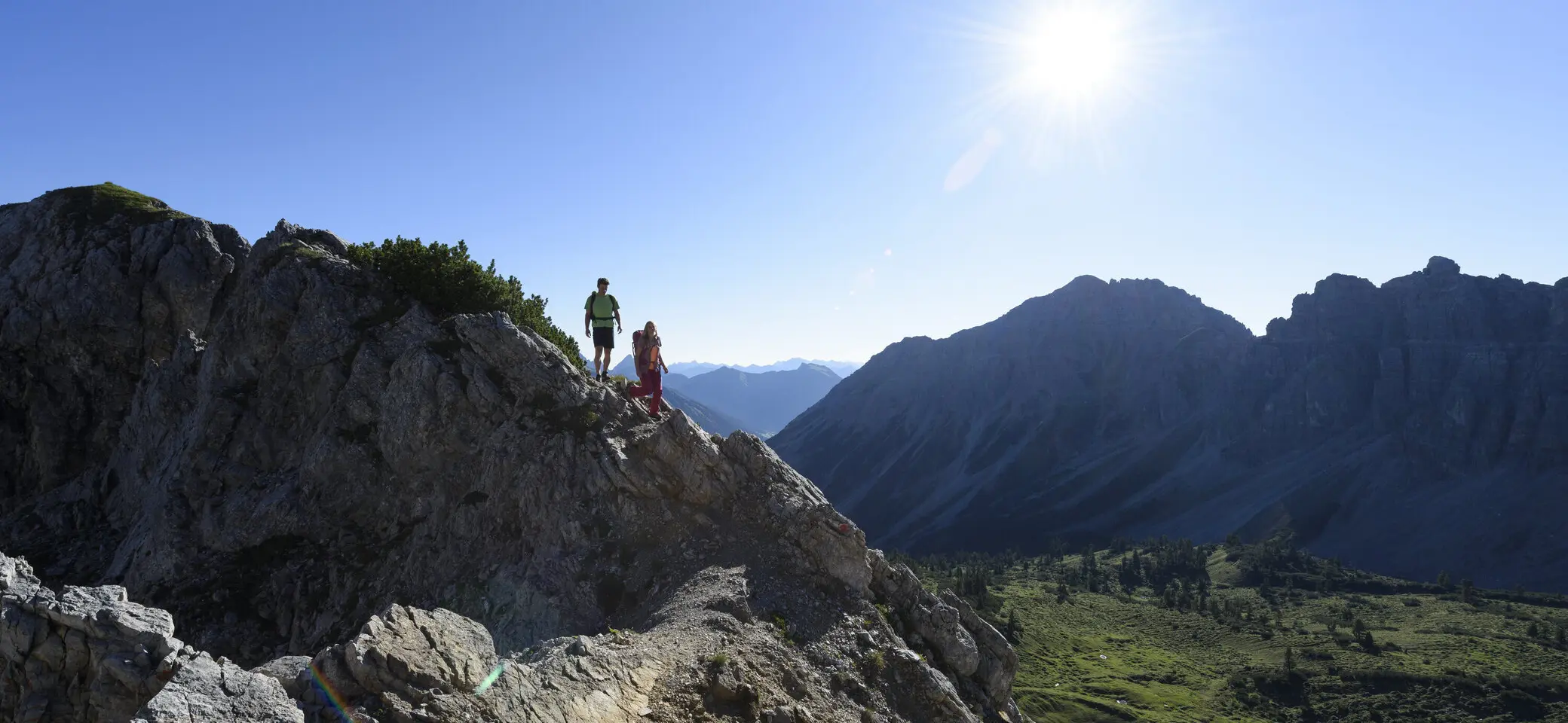 Panoramaaufname von Berggipfeln mit zwei Wanderern | © DAV/Wolfgang Ehn